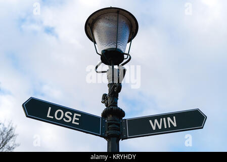 Lose versus Win directional signs on guidepost Stock Photo