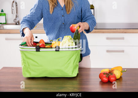 Woman Removing Vegetable From Grocery Bag Stock Photo