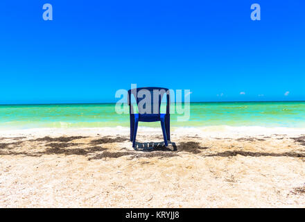 A chair sitting in the sand and looking at the ocean at a Yucatan Peninsula Beach Stock Photo