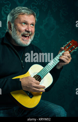 Studio portrait of senior man with guitar. Stock Photo