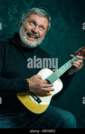 Studio portrait of senior man with guitar. Stock Photo