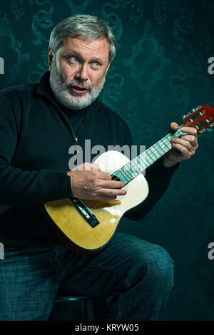 Studio portrait of senior man with guitar. Stock Photo