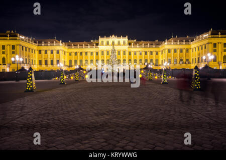 View of illuminated Schönbrunn palace in Christmas time with fairy lights decorated Christmas tree at dusk in Advent. Stock Photo