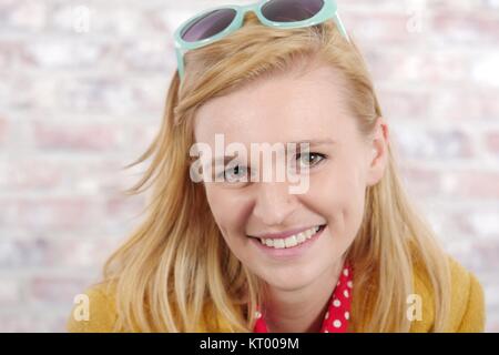 beautiful young blonde woman with a yellow jacket Stock Photo