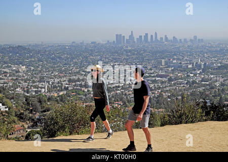 Two people hiking up trail path to Griffith Park Observatory in Griffith Park hills & cityscape of downtown Los Angeles, California USA   KATHY DEWITT Stock Photo