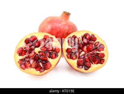 Whole red pomegranate and two cut halves showing seeds Stock Photo