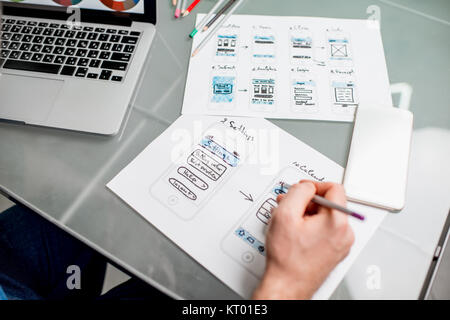 UX designer working on the mobile application experience sketching drawings at the office. Image focused no the drawsings cropped with no face Stock Photo