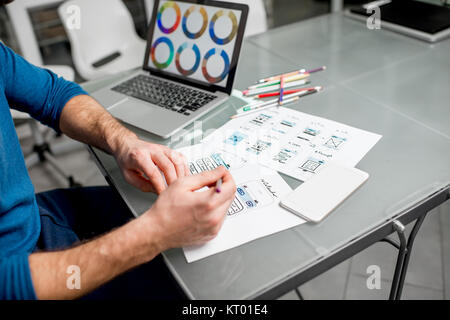 UX designer working on the mobile application experience sketching drawings at the office. Image focused no the drawsings cropped with no face Stock Photo