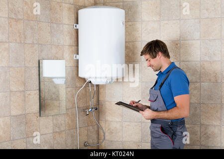 Plumber Writing On Clipboard Stock Photo