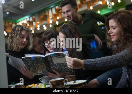 Group of teenagers doing homework in cafe. Stock Photo
