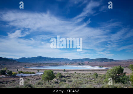 Reservoir in the landscape with motion blur on the clouds Stock Photo