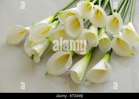 Bunch of arum lily on white background, white flower from clay with yellow stamen, handmade artwork from clay art Stock Photo