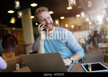 Young man having phone call in coffee shop Stock Photo