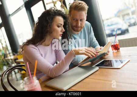 Portrait of young students reading book and talking Stock Photo