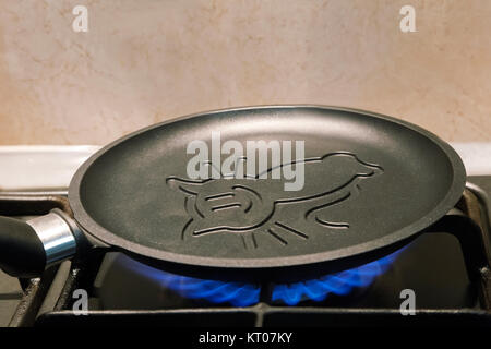 https://l450v.alamy.com/450v/kt07ky/on-fire-of-the-gas-stove-heats-up-a-cast-iron-frying-pan-for-pancakes-kt07ky.jpg