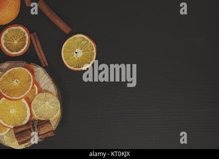 Black wood background with slices of orange and lemon Stock Photo