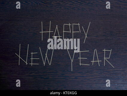 The inscription Happy New Year 2018 on a dark wooden surface with a matte shade made of pasta Stock Photo