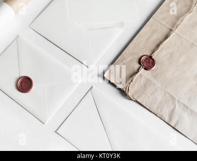 Envelopes and seal stamp on paper background. Vintage still life with postal accessories. Blank stationery. Responsive design mockup.