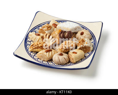 Dish with traditional variety of festive Moroccan cookies on white background Stock Photo