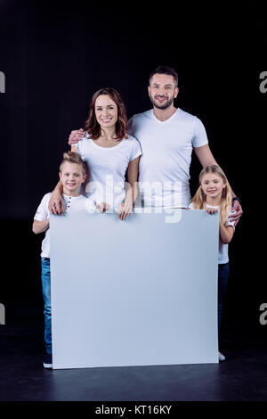 Smiling family holding blank card Stock Photo