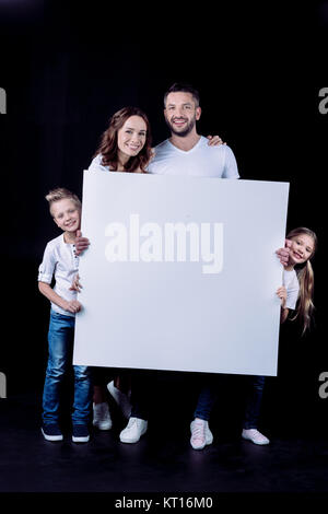 Smiling family holding blank card Stock Photo