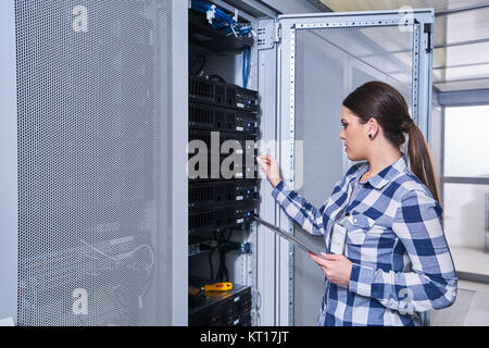 female technician working on server maintenance in white server room Stock Photo