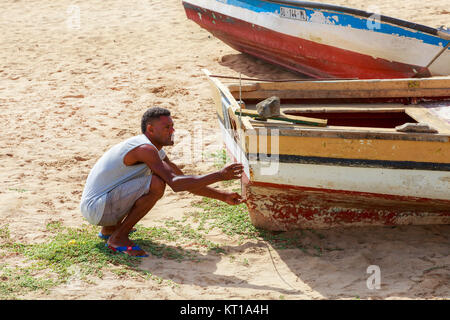 local fisherman repairing his wooden fishing boat on the beach at Santa Maria, Sal Island, Salina, Cape Verde, Africa Stock Photo
