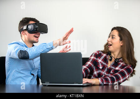 Couple having fun trying VR headset at startup meeting, concept, teamwork, fun Stock Photo