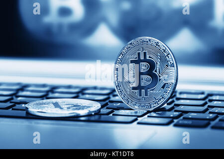 Blue close up golden bitcoin coin crypto Currency background concept. Golden bitcoin coin on the black laptop keyboard. Macro. Blue colored Stock Photo