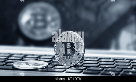 Blue close up golden bitcoin coin crypto Currency background concept. Golden bitcoin coin on the black laptop keyboard. Macro. Blue colored Stock Photo