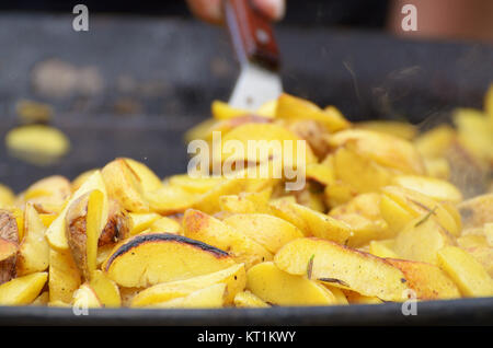 In a large frying pan prepares a large portion of fried potatoes. Stock Photo