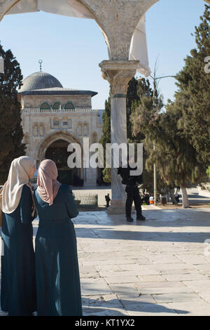 Palestinian women watch as Israeli security forces cordon off AL-Aqsa Mosque to allow Jewish worshippers in to the complex. Stock Photo