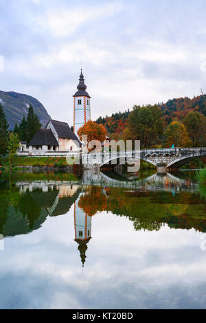 Church tower and stone bridge at Lake Bohinj Stock Photo