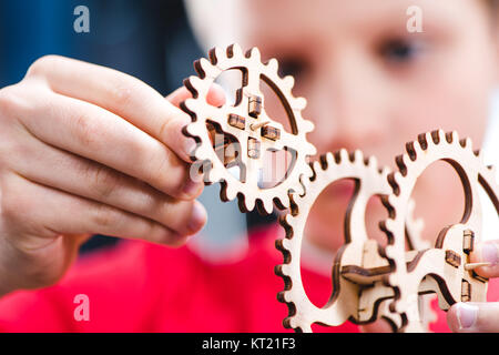 Kid holding wooden gear toy Stock Photo
