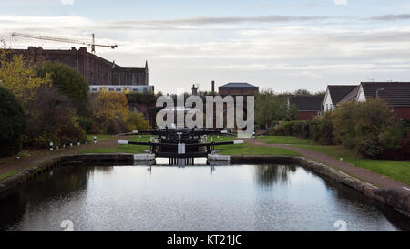 Liverpool, England, UK - November 12, 2016: A Merseyrail metro train crosses the Leeds & Liverpool canal at the Stanley Dock flight of locks in the Va Stock Photo