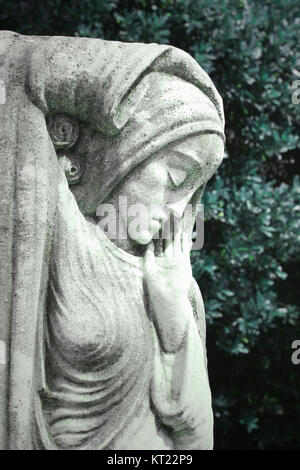 Detail of a beautiful elegant female sculpture with plants on the background Stock Photo