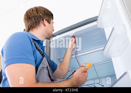 Male Technician Checking Refrigerator Stock Photo