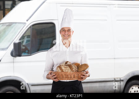 Baker Holding A Basket Full Of Bread Loaf Stock Photo