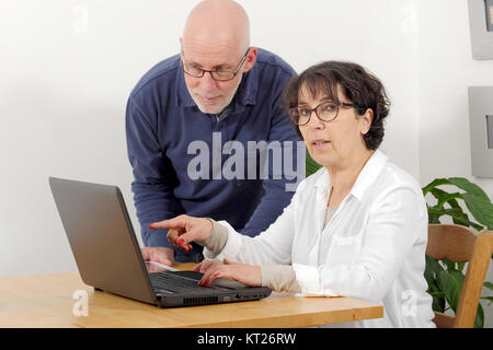 Portrait of a happy senior couple using laptop Stock Photo