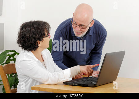 Portrait of a happy senior couple using laptop Stock Photo