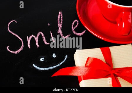 Cup of Coffee and Present. Inscription Smile. Stock Photo