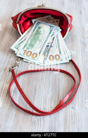 100 dollars banknotes fall out from red handbag Stock Photo