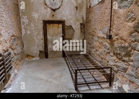 Typical cell with abandoned bed frame in the Eastern State Penitentiary Historic Site, Philadelphia, United States. Stock Photo