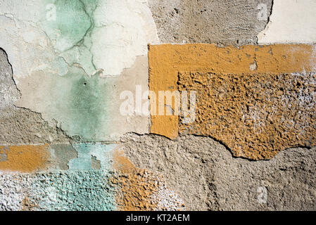 Background of an old wall with peeling plaster and yellow faded paint and green mold Stock Photo