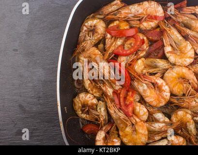 Cooked Fresh Shrimp with Tomato and Onions / Cooked Fresh Shrimp with Tomato and Onions Served in a plate on a Wooden ( Black Ceramic) background Stock Photo