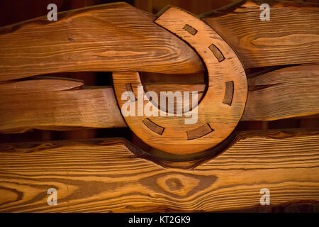 On wooden boards carved wooden horseshoe.Symbol of luck. Texture of a tree. Horseshoe. Textured board Stock Photo