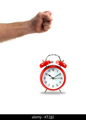 An alarm clock and a fist isolated against a white background Stock Photo