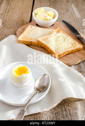 Boiled egg with crispy toasts on the wooden table Stock Photo