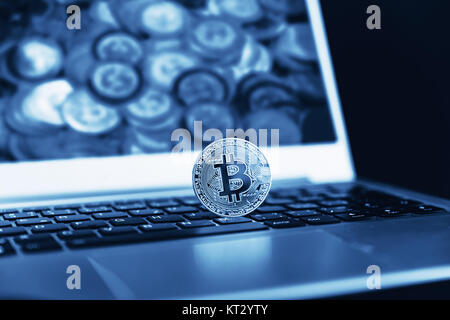 Blue close up golden bitcoin coin crypto Currency background concept. Golden bitcoin coin on the black laptop keyboard. Macro. Blue colored Stock Photo