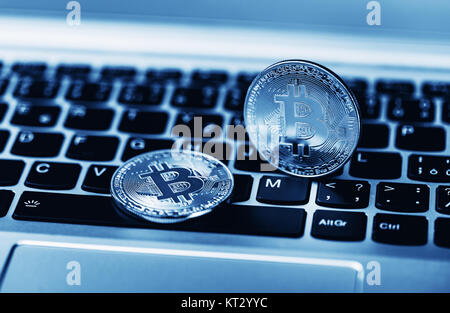 Blue close up golden bitcoin coin crypto Currency background concept. Golden bitcoin coin on the black laptop keyboard. Macro. Blue colored Stock Photo